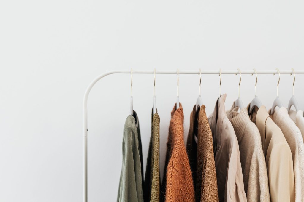 Portant minimaliste de vêtements aux teintes neutres dans un intérieur épuré